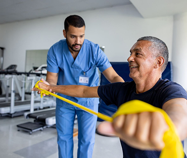 Physical therapist supervising resistance band arm strengthening exercise during rehabilitation at Fort Lee PT in Fort Lee NJ